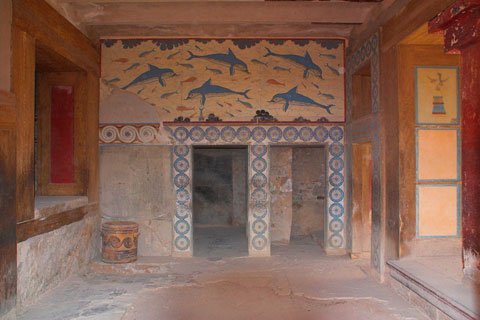 Room with dolphin frescoes and decorated walls and pillars.